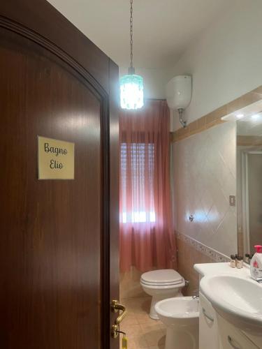 a bathroom with a toilet and a door with a sign on it at Affittacamere da Elio e Renata in Calvi dellʼ Umbria