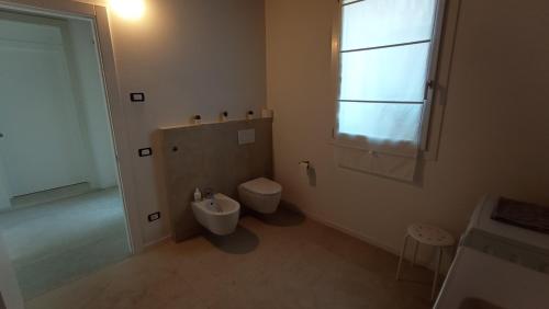 a bathroom with a toilet and a sink and a window at Agriturismo Casa Bregalda in Castelgomberto