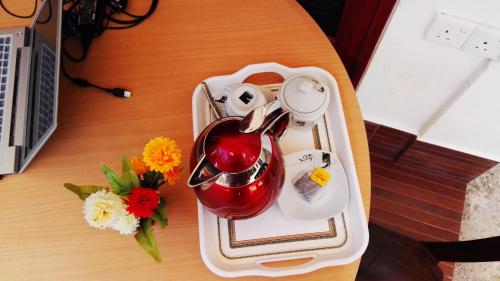 uma bandeja com uma chaleira e flores sobre uma mesa em Sevonrich Holiday Resort em Dambulla