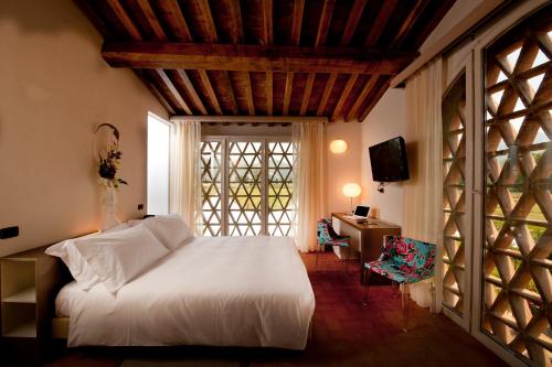 a bedroom with a white bed and a window at Locanda Sant'Agata in San Giuliano Terme