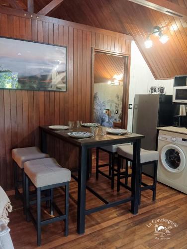 a kitchen with a table and chairs and a refrigerator at Le chalet Bambou in Étang-Salé