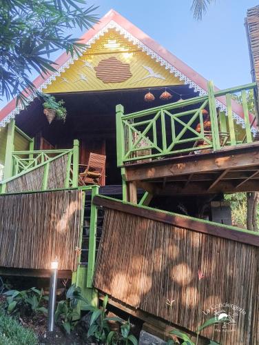 a house with green and yellow at Le chalet Bambou in Étang-Salé