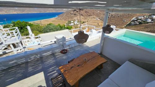 a balcony with a bench and a swimming pool at Villa Chronos with private pool in Mýkonos City