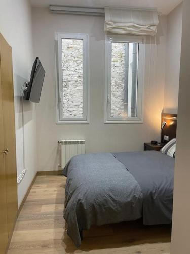 a bedroom with a bed and two windows at Marinera in Luarca
