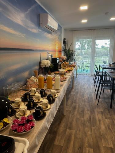 a long table with plates of food on it at See Panzió in Fertőrákos