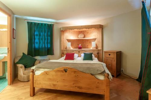 - une chambre avec un lit en bois et quatre oreillers dans l'établissement LA PLOCHE 6, à Morzine