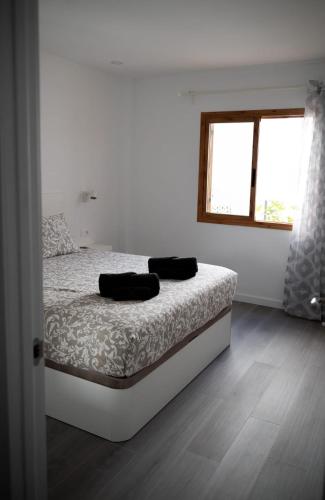 a bedroom with a bed with two black towels on it at Los Cristianos Aqua Viva in Los Cristianos