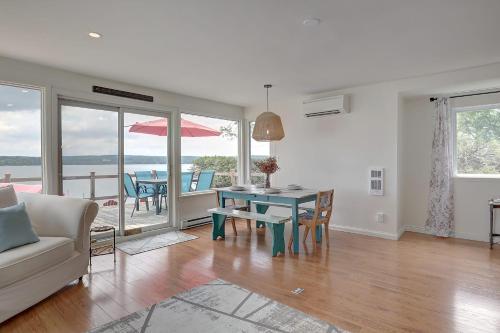 a living room with a table and chairs and a balcony at La Cozy O-Lac Magog in Sherbrooke