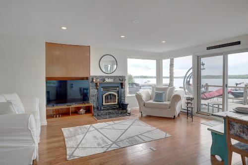 a living room with a fireplace and a chair at La Cozy O-Lac Magog in Sherbrooke
