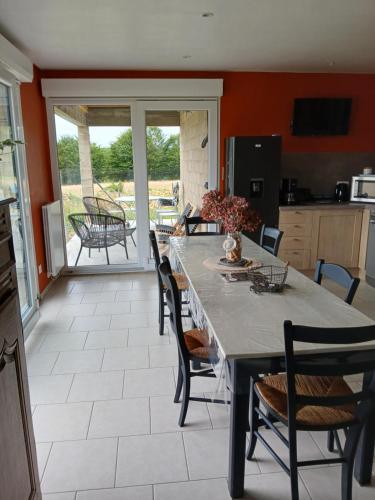 une cuisine avec une grande table et des chaises et une cuisine avec une terrasse dans l'établissement la clé du bouton d'or, à Leschelles