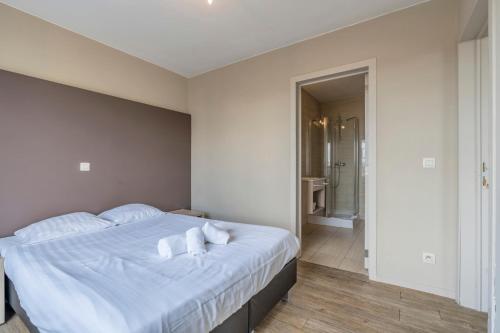 a bedroom with a white bed with towels on it at Value Stay Residence Mechelen in Mechelen