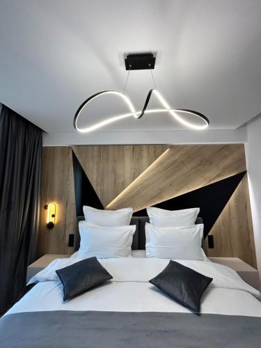 a bedroom with a large white bed with black pillows at MONARC Boutique ApartHotel - SELF CHECK-IN in Iaşi