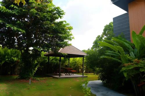 a gazebo with a picnic table in a yard at Na Napa Wellness Spa & Resort in Chiang Mai