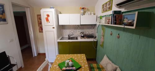 a small kitchen with a green refrigerator and a table at Le Coin Vert in Fregene