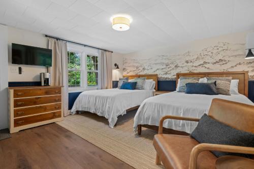a bedroom with two beds and a couch at The Aurora Inn & Cottages in Bartlett