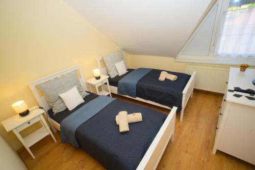 a bedroom with two beds and a window at Vadrózsa apartman in Sümeg