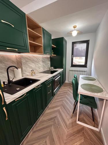 a green kitchen with a sink and a table at MONARC Boutique ApartHotel - SELF CHECK-IN in Iaşi