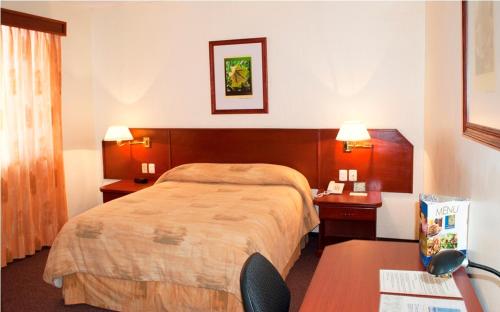 a hotel room with a bed and a desk at Hotel Marcella Clase Ejecutiva in Morelia