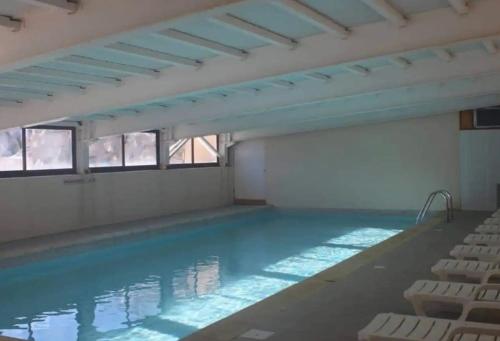 une piscine vide avec des chaises dans un bâtiment dans l'établissement Beautiful central 2 bedrooms apartment in Auron, à Saint-Étienne-de-Tinée