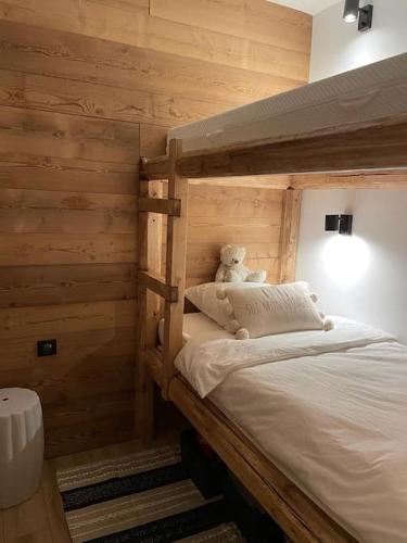 - un ours en peluche assis sur un lit dans une pièce dans l'établissement Beautiful central 2 bedrooms apartment in Auron, à Saint-Étienne-de-Tinée