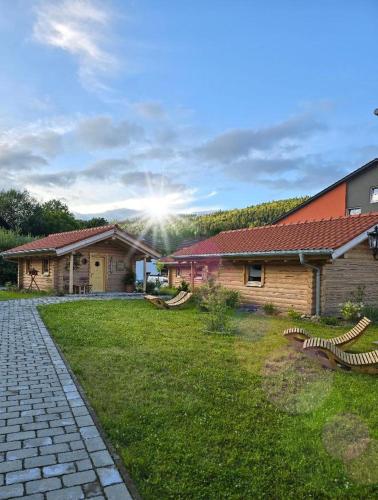 a house with a grass yard next to a building at Chalet Hüttendorf 49 gradnord in Bayerisch Eisenstein
