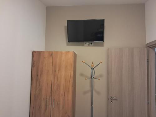 a tv on a wall next to two wooden cabinets at Four Seasons in Leptokaria