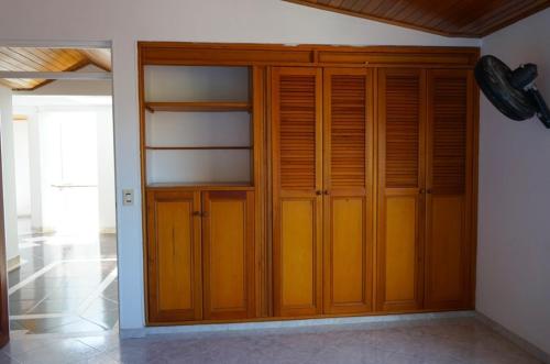 a closet with wooden doors in a room at Finca tres colinas in Lemos