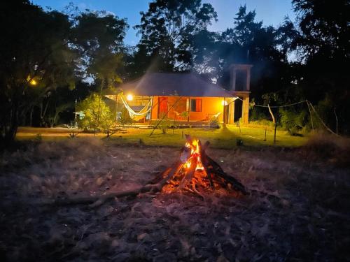 a campfire in front of a house at night at Sahana Retreat in Buttala