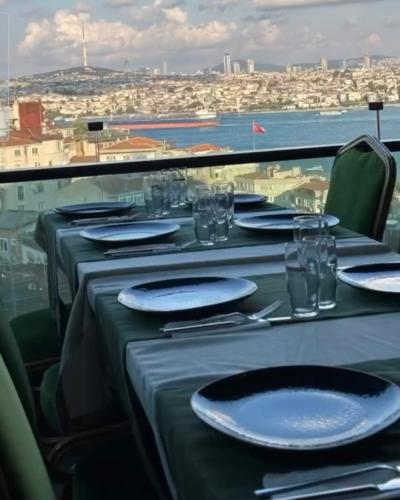 a table with plates and glasses and a view of a city at Grand Star Hotel Premium in Istanbul