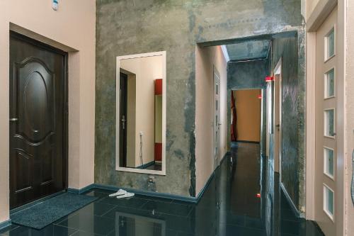 een hal met een spiegel aan de muur en een hal met een deur bij Apartment Penthouse in Kiev