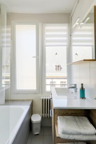 une salle de bain avec une baignoire, un lavabo et des toilettes dans l'établissement La cathédrale - Vue sur Seine, à Rouen