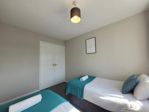 a bedroom with two beds and a closet at President Road- A Spacious and homely four bed house by Catchpole Stays in Lexden