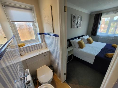 a small bedroom with a bed and a toilet at President Road- A Spacious and homely four bed house by Catchpole Stays in Lexden
