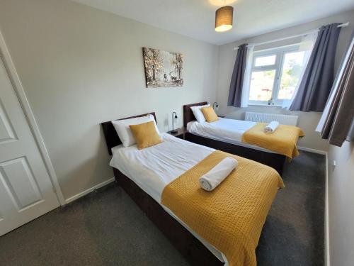 a room with two beds and a window at President Road- A Spacious and homely four bed house by Catchpole Stays in Lexden