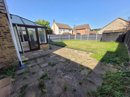 a backyard with a house and a fence at President Road- A Spacious and homely four bed house by Catchpole Stays in Lexden