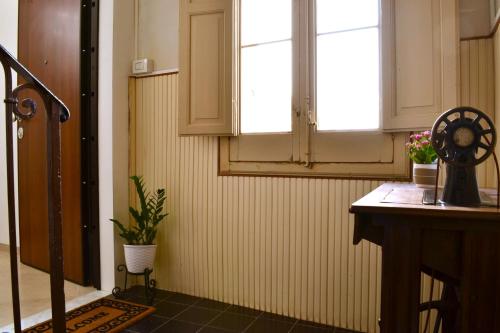 a room with a window and a table with a fan at La Donzella - Centro storico Scicli in Scicli