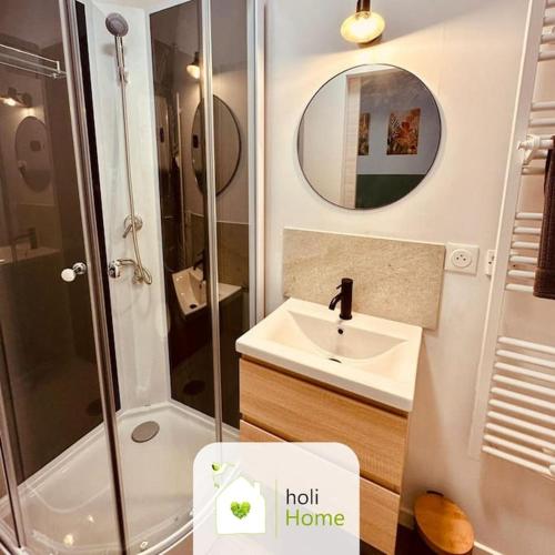 une salle de bain avec une douche, un lavabo et un miroir dans l'établissement H8-4 Petite parenthèse de la Villéon, à Fougères