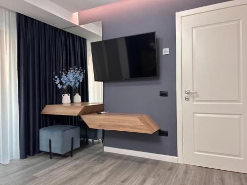 a room with a table and a television on a wall at MONARC Boutique ApartHotel - SELF CHECK-IN in Iaşi