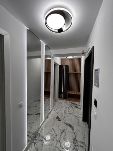 a hallway with marble floors and a ceiling with a light fixture at MONARC Boutique ApartHotel - SELF CHECK-IN in Iaşi
