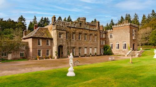 an old castle with a statue in front of it at Kentchurch Court in Kentchurch