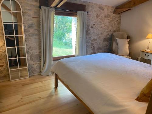 une chambre avec un grand lit et une fenêtre dans l'établissement Le Noyer sur Lot, à Prayssac