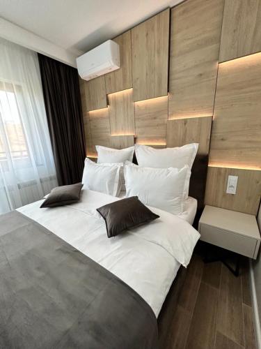 a bedroom with a large bed with white sheets and pillows at MONARC Boutique ApartHotel - SELF CHECK-IN in Iaşi
