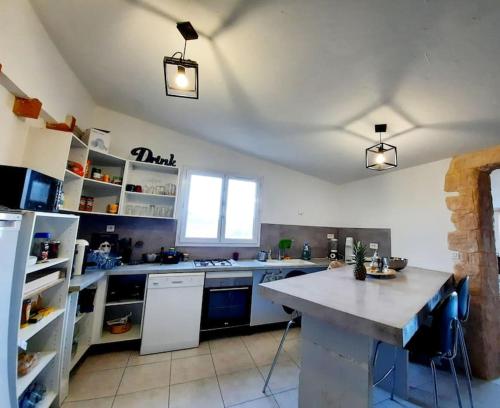 - une grande cuisine avec un grand comptoir dans une pièce dans l'établissement Maison avec piscine, à Alata