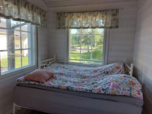 a bed in a room with a window at Tiny house with sauna and hot tub close to archipelago in Töfsala