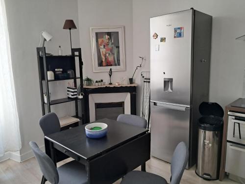 une salle à manger avec une table et un réfrigérateur dans l'établissement In the heart of Le Marais Paris, à Paris