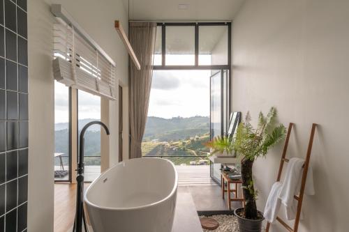 un bagno con vasca e una grande finestra di Bon r kaad a Chiang Mai
