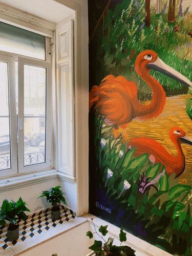 a painting of two flamingos on a wall next to a window at WOT Lisbon Patio in Lisbon