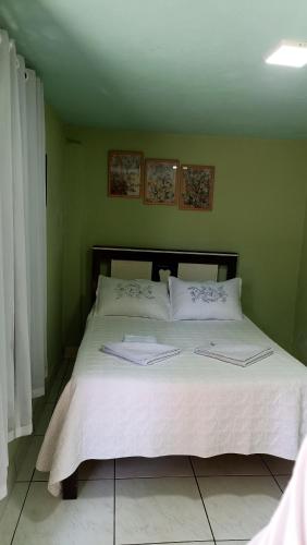 a bed in a bedroom with two pillows on it at Casa de Vivendas in Domingos Martins