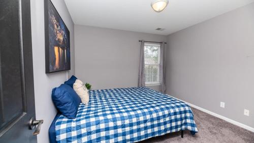 a bedroom with a blue bed and a window at Charming, Spacious, Ideal 4 Groups Near Charleston in Charleston