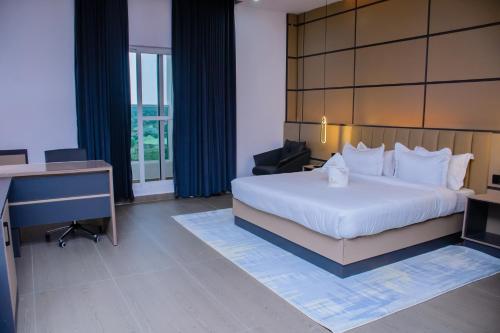 ein Hotelzimmer mit einem Bett und einem Schreibtisch und einem Schreibtisch in der Unterkunft G-Pinnacle Signature in Ilorin